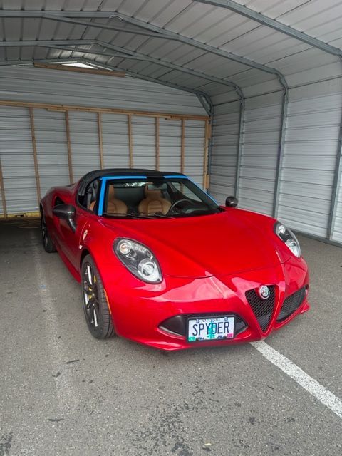 A red sports car with a license plate that says spider