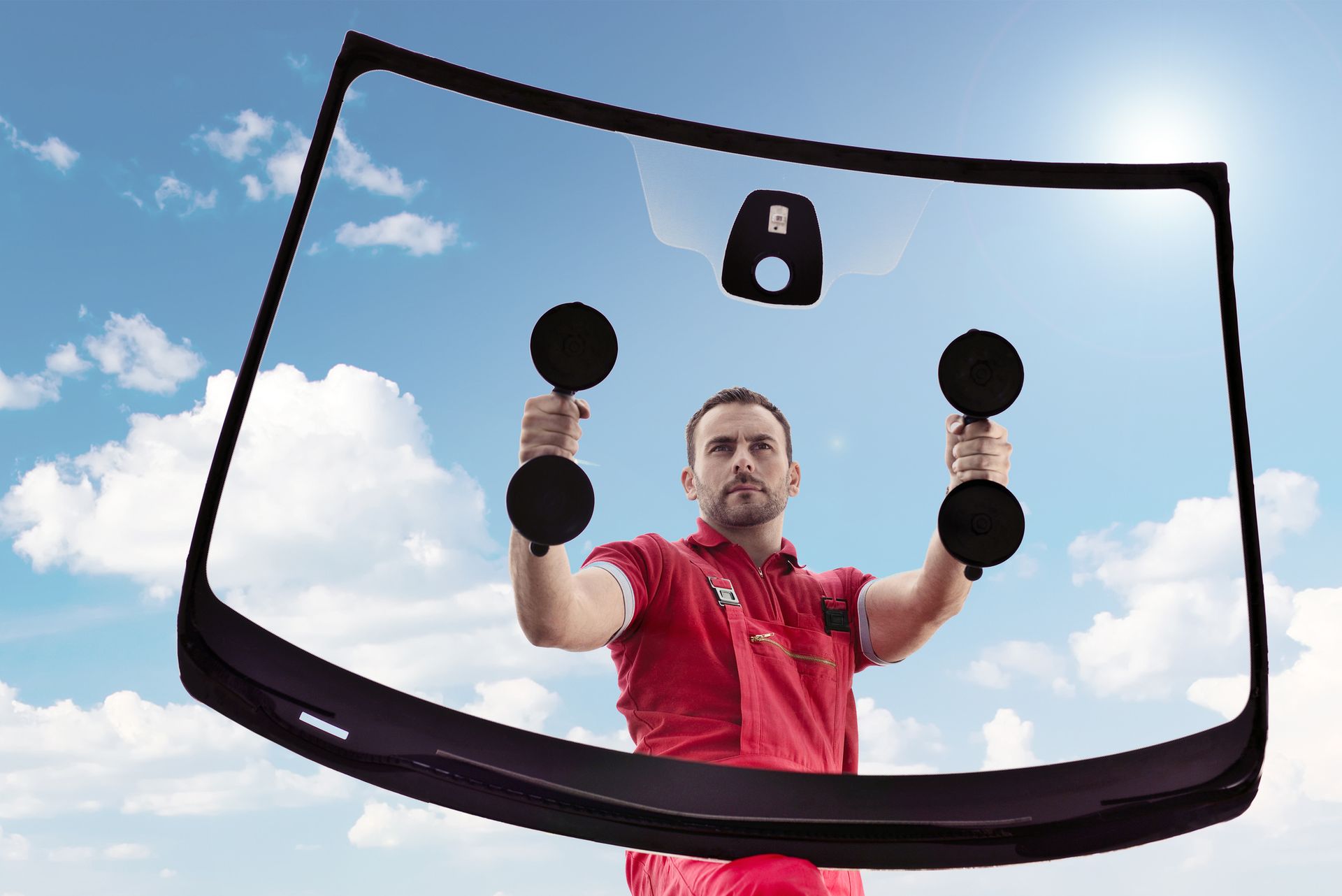 A man lifting a car windshield, illustrating the process of auto glass replacement in Portland, OR