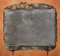 An old radiator is sitting on a tiled floor