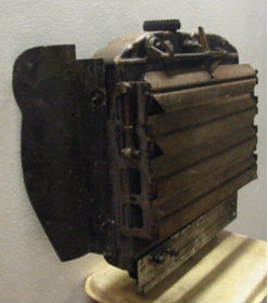 A very old piece of metal is sitting on a wooden table
