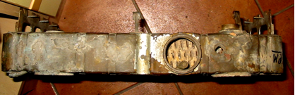 A rusty piece of metal is sitting on a tiled floor.