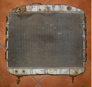 An old radiator is sitting on a tiled floor