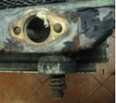 A piece of metal with holes in it is sitting on a tiled floor.