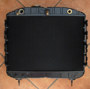 A black radiator is sitting on a tiled floor