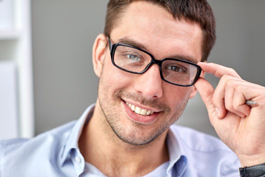 smiling businessman in eyeglasses face in office