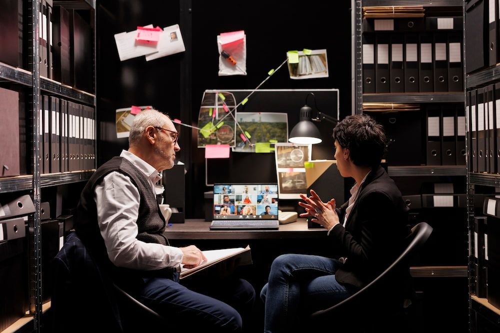 A Man And A Woman Are Sitting At A Desk Talking To Each Other — Surveillance NQ In Aitkenvale, QLD