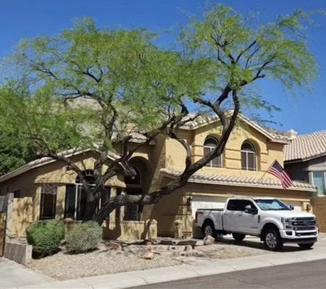 A white truck is parked in front of a house.