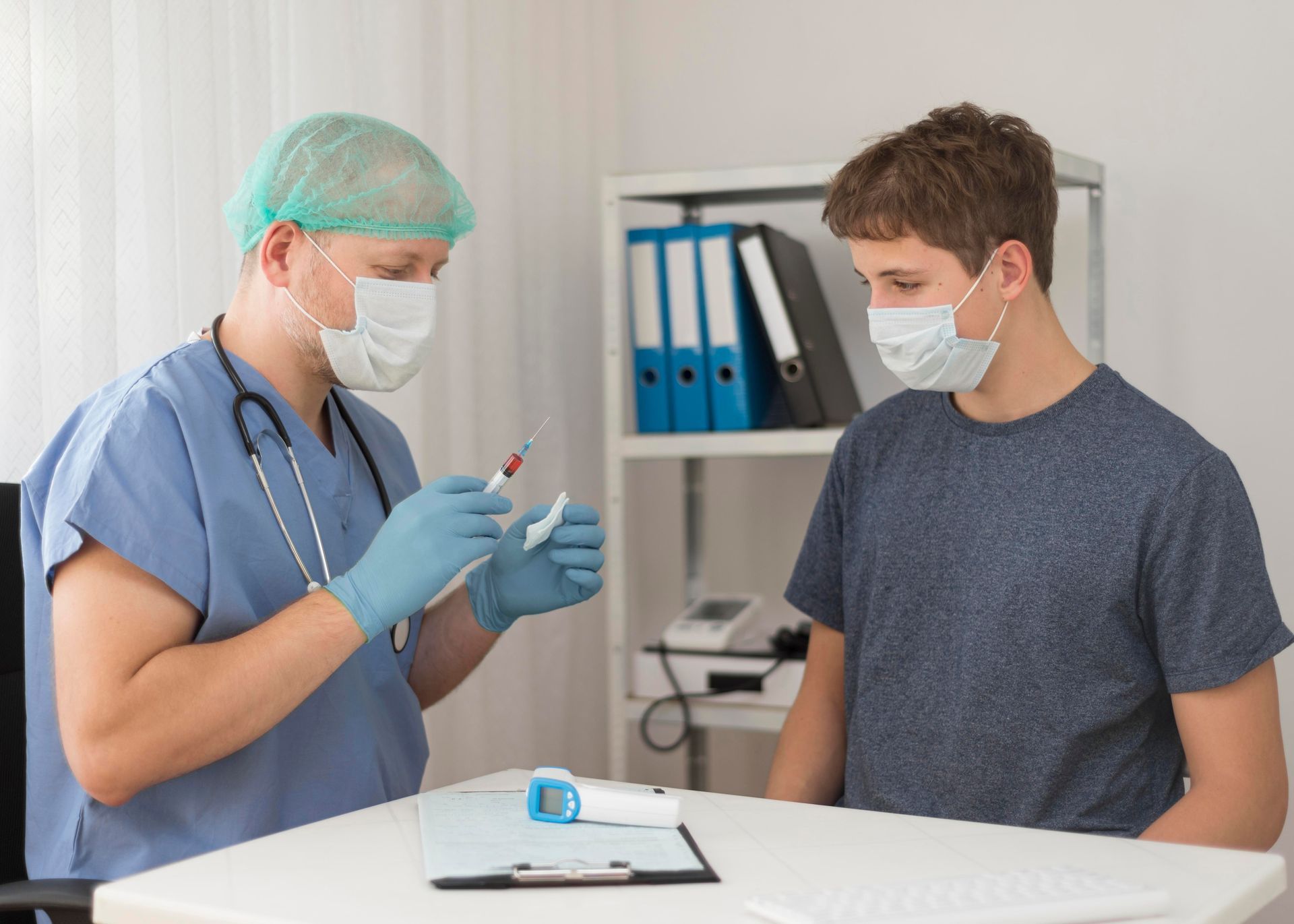 Healthcare worker showing a syringe to a masked patient in a clinic room