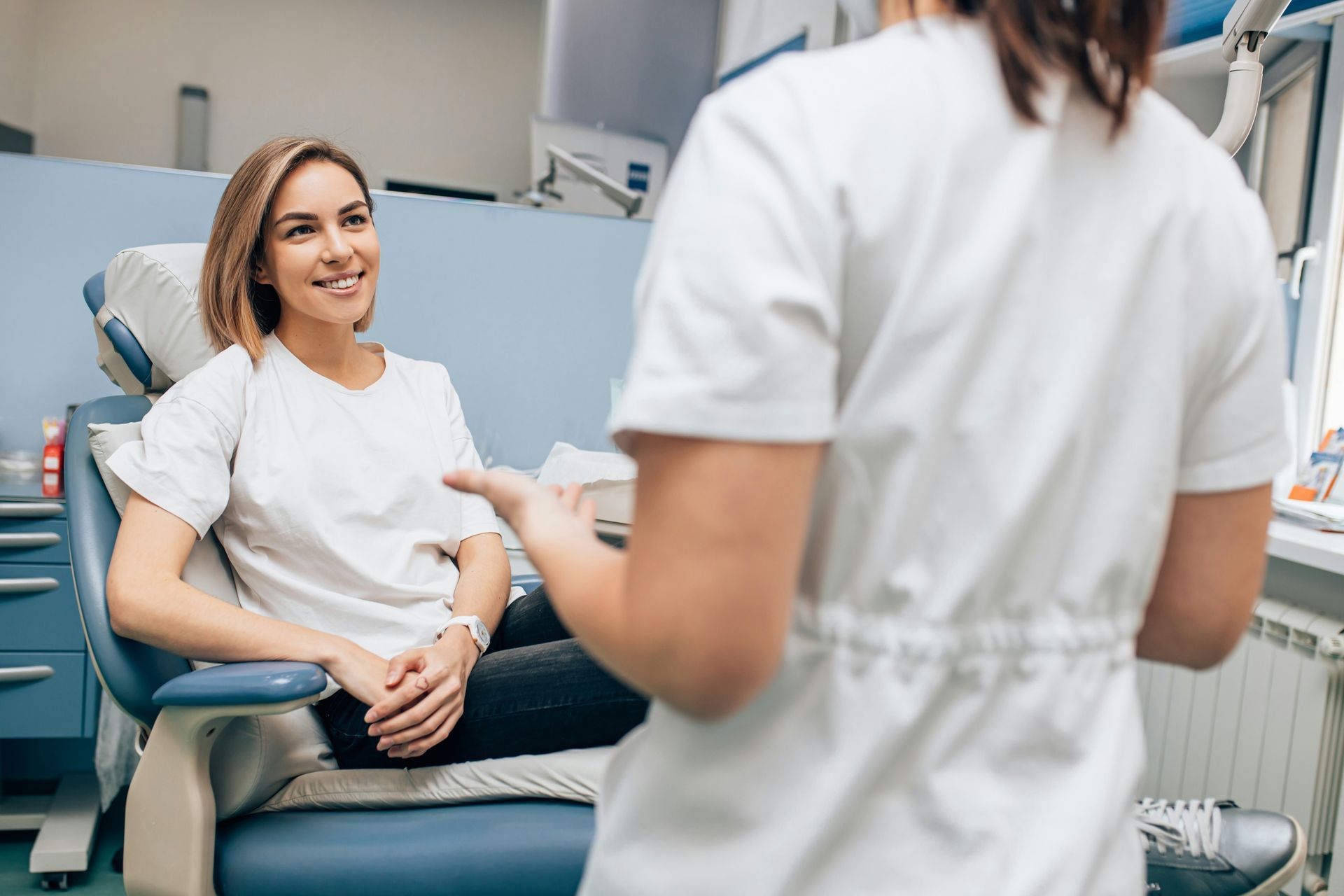 Patient smiling during a dental consultation with a clinician in a modern office