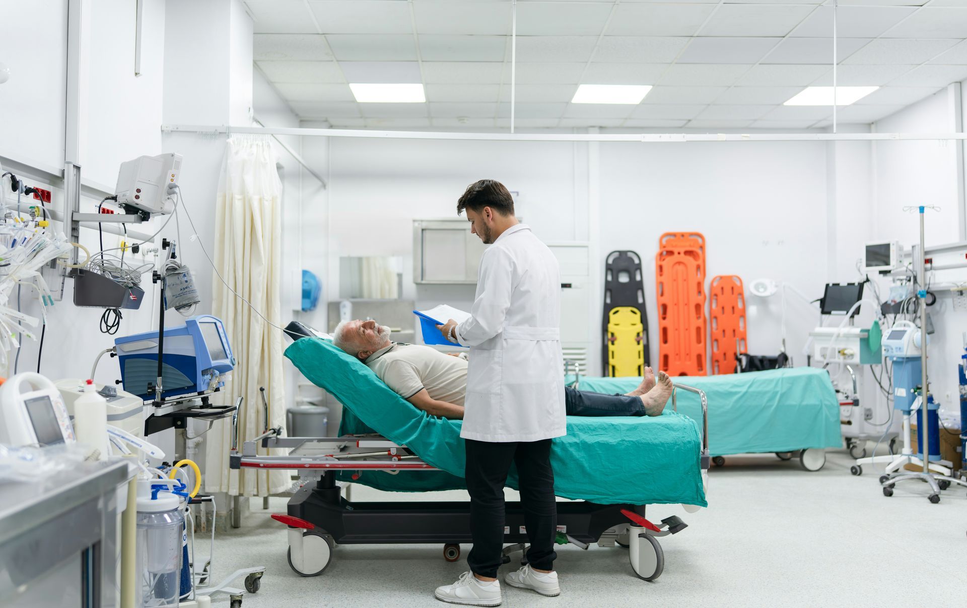 Medical staff tending to a patient on a hospital bed in a bright ICU room