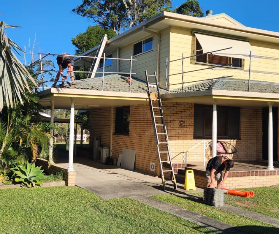 A man is working on the roof of a house.