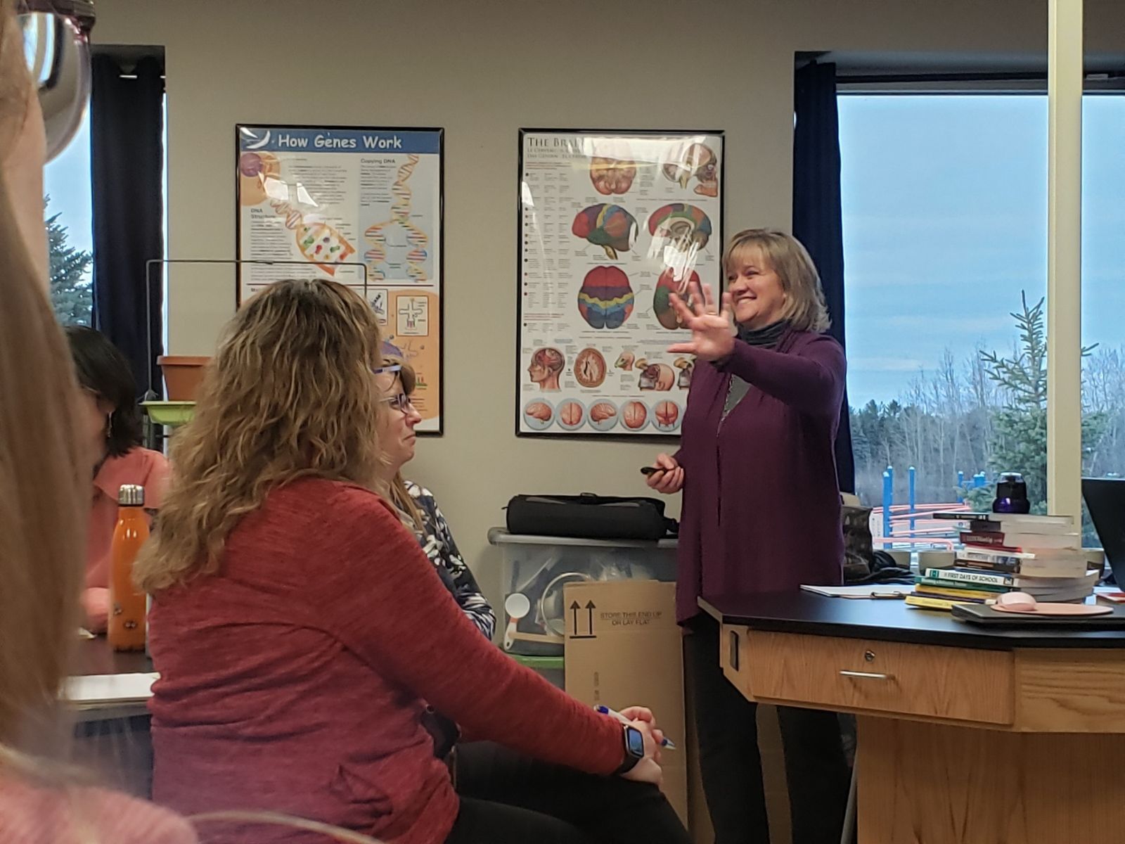 A woman is giving a presentation to a group of people in a classroom.