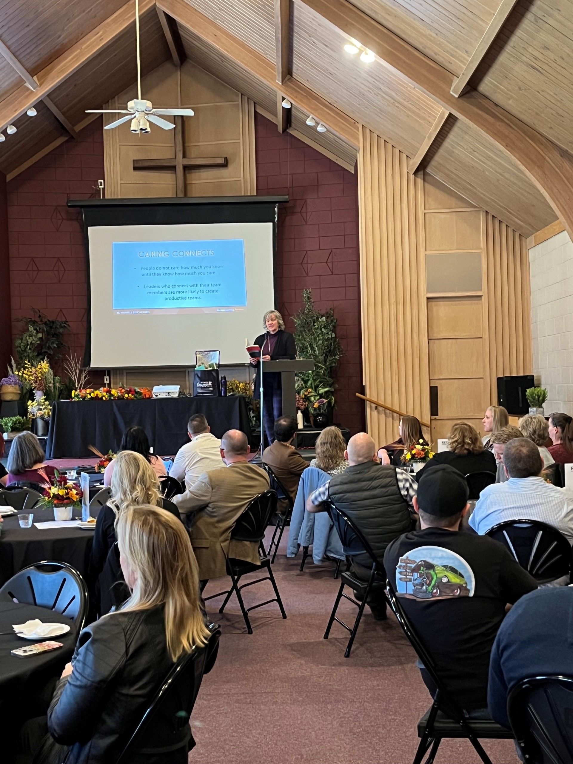 A woman is giving a presentation to a group of people in a church.