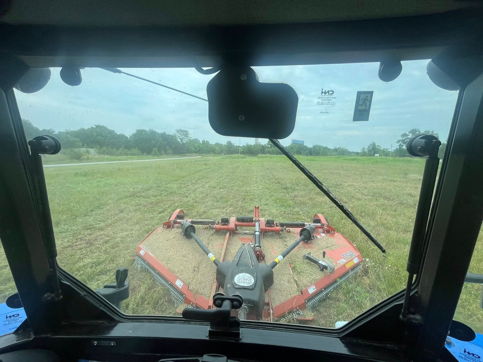 View from tractor cab mowing a field.