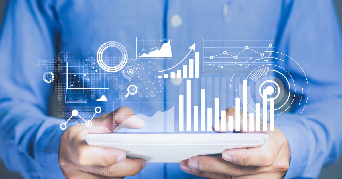 a man in a blue shirt holding an tablet which has holographic data/graphs coming from it