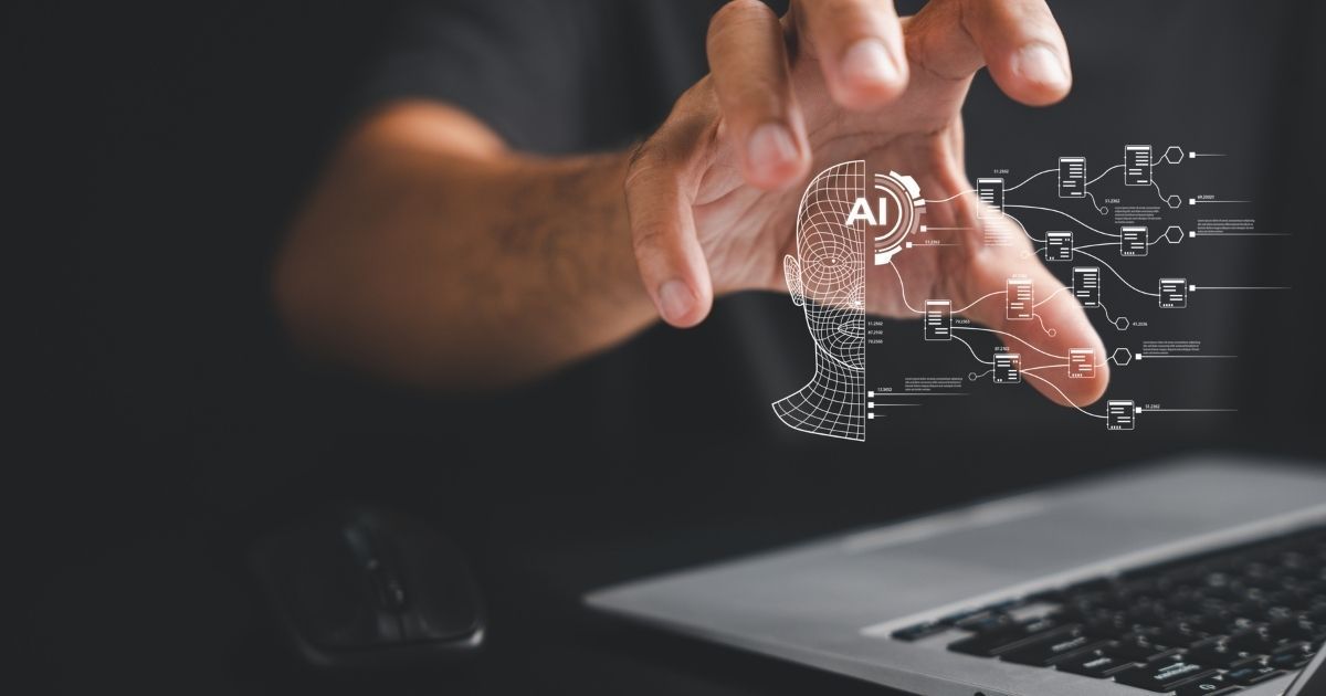 Hand reaching for a glowing AI brain outline above a laptop, symbolizing artificial intelligence.