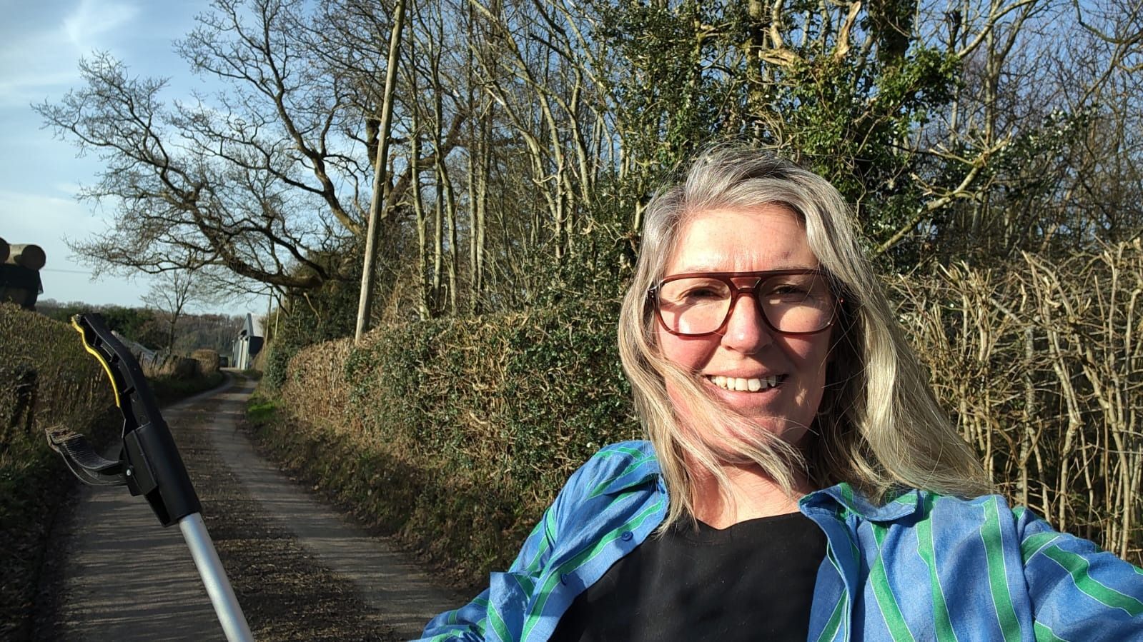 a selfie of Christa Swain holding up a litter picker grabber