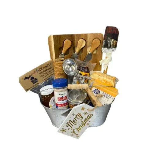 Cheese and cracker gift basket with various toppings, cutting board, and utensils.