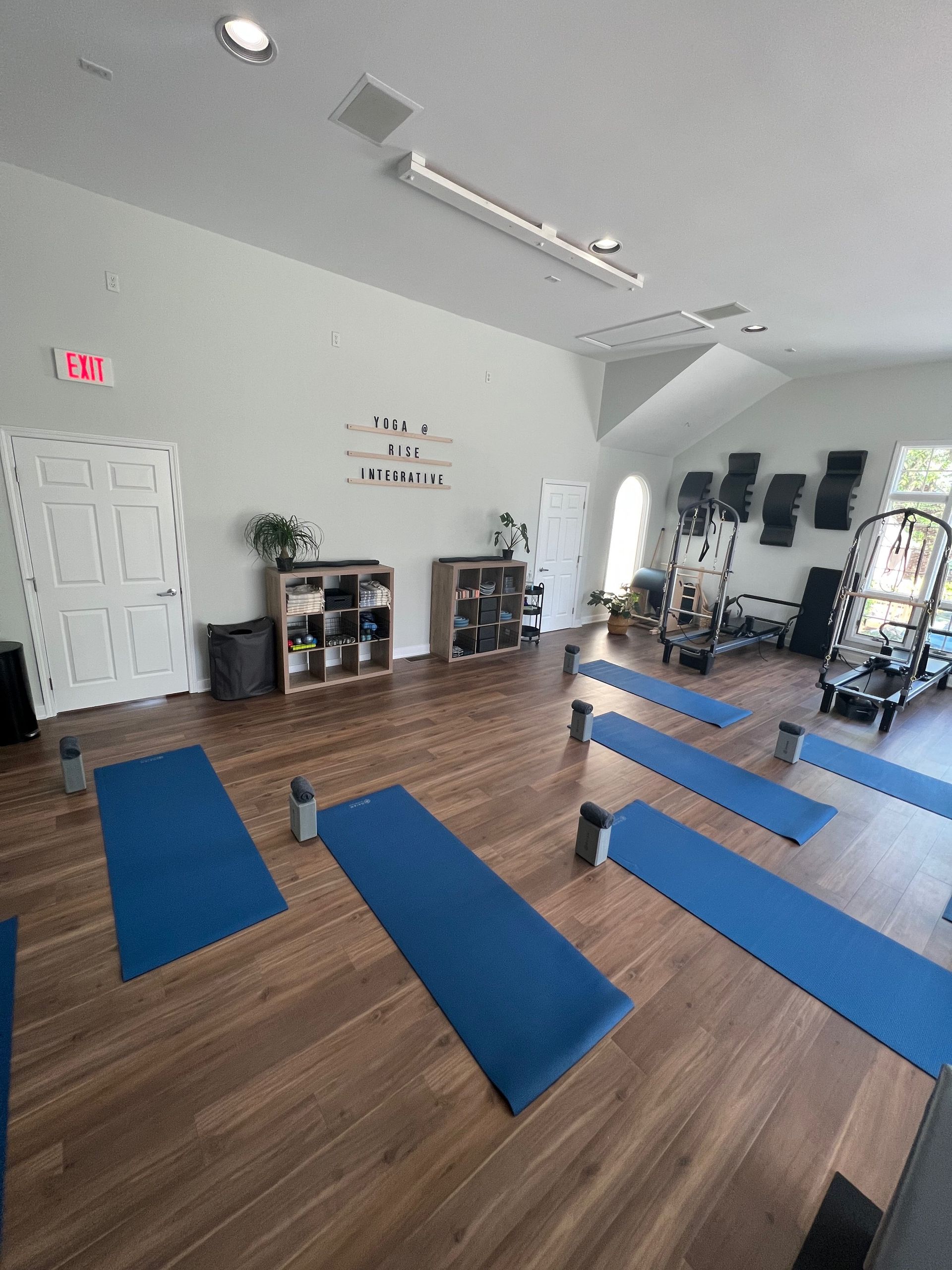 A room with many blue yoga mats on the floor