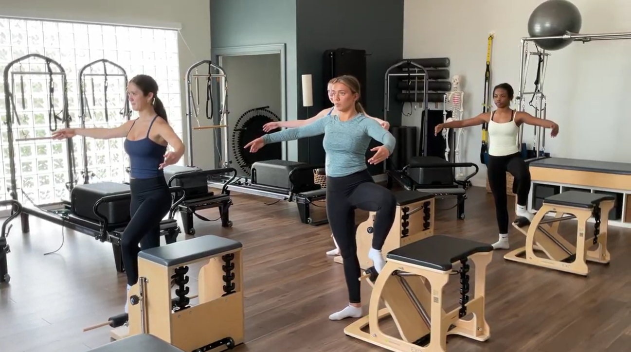 A large room with pilates equipment and natural lighting with modern decor