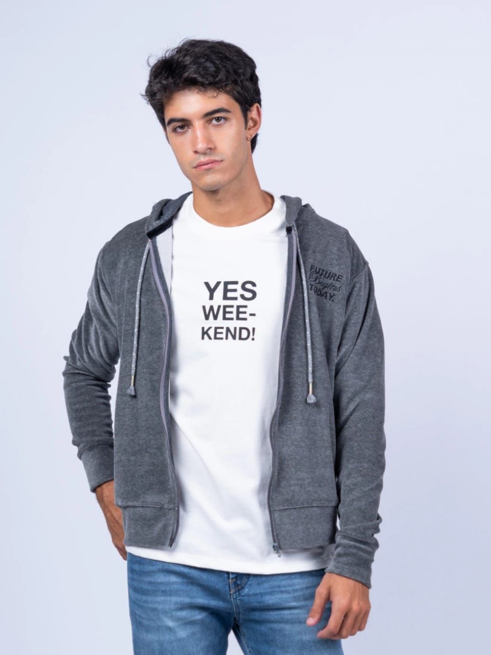 Hombre joven con sudadera gris y camisa blanca con texto