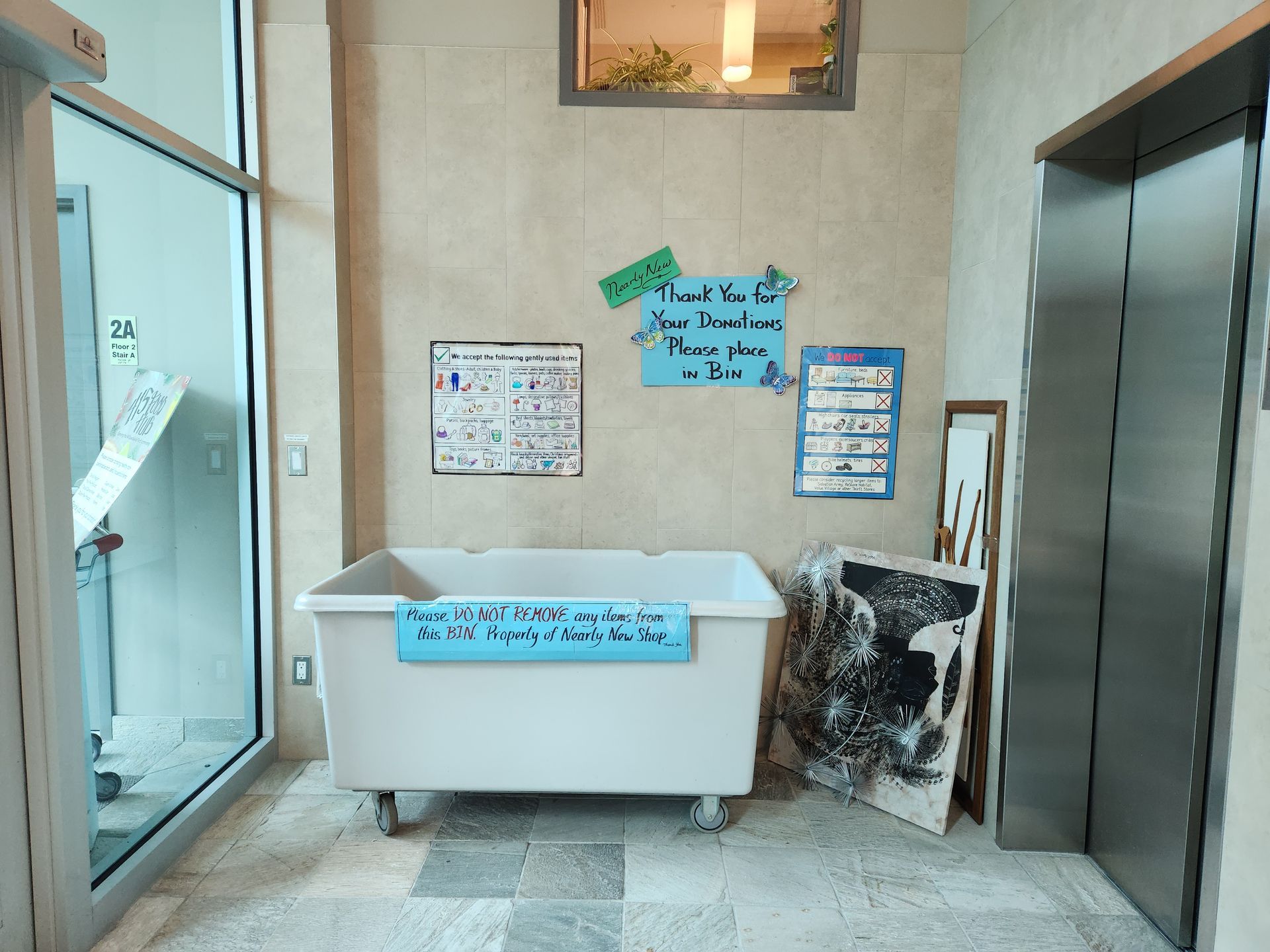 Image of our large donation bin inside our main entrance, in front of the elevator.