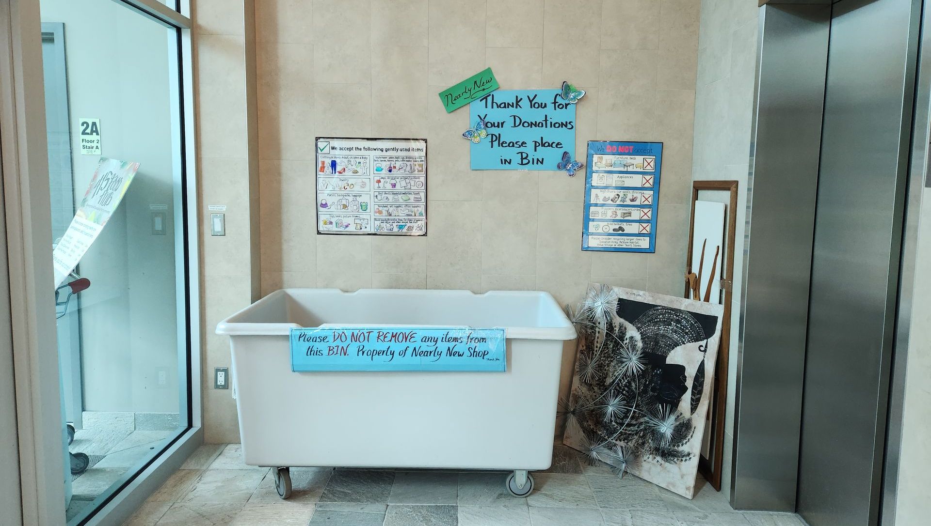 Image of our large donation bin inside our main entrance, in front of the elevator.