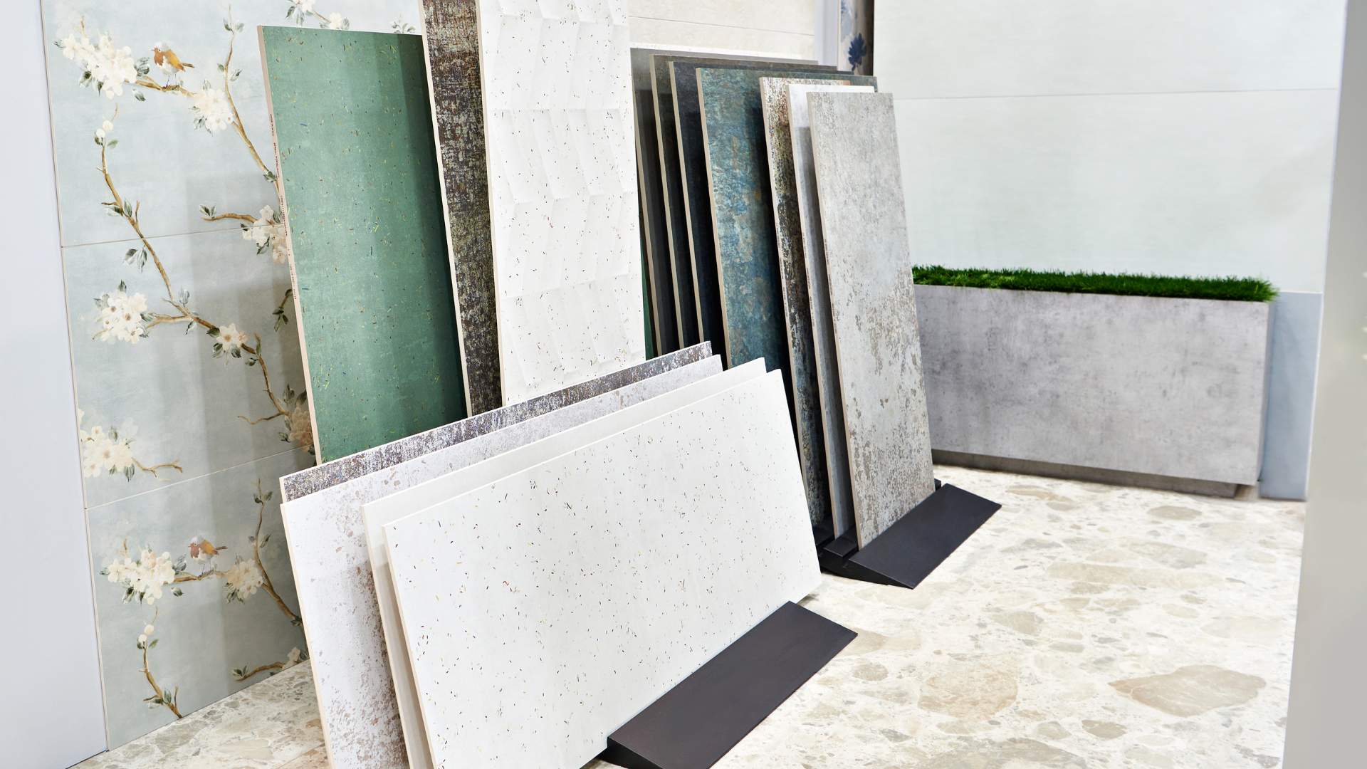 A display of various stone and quartz slab samples in different colors and patterns standing upright in a showroom.