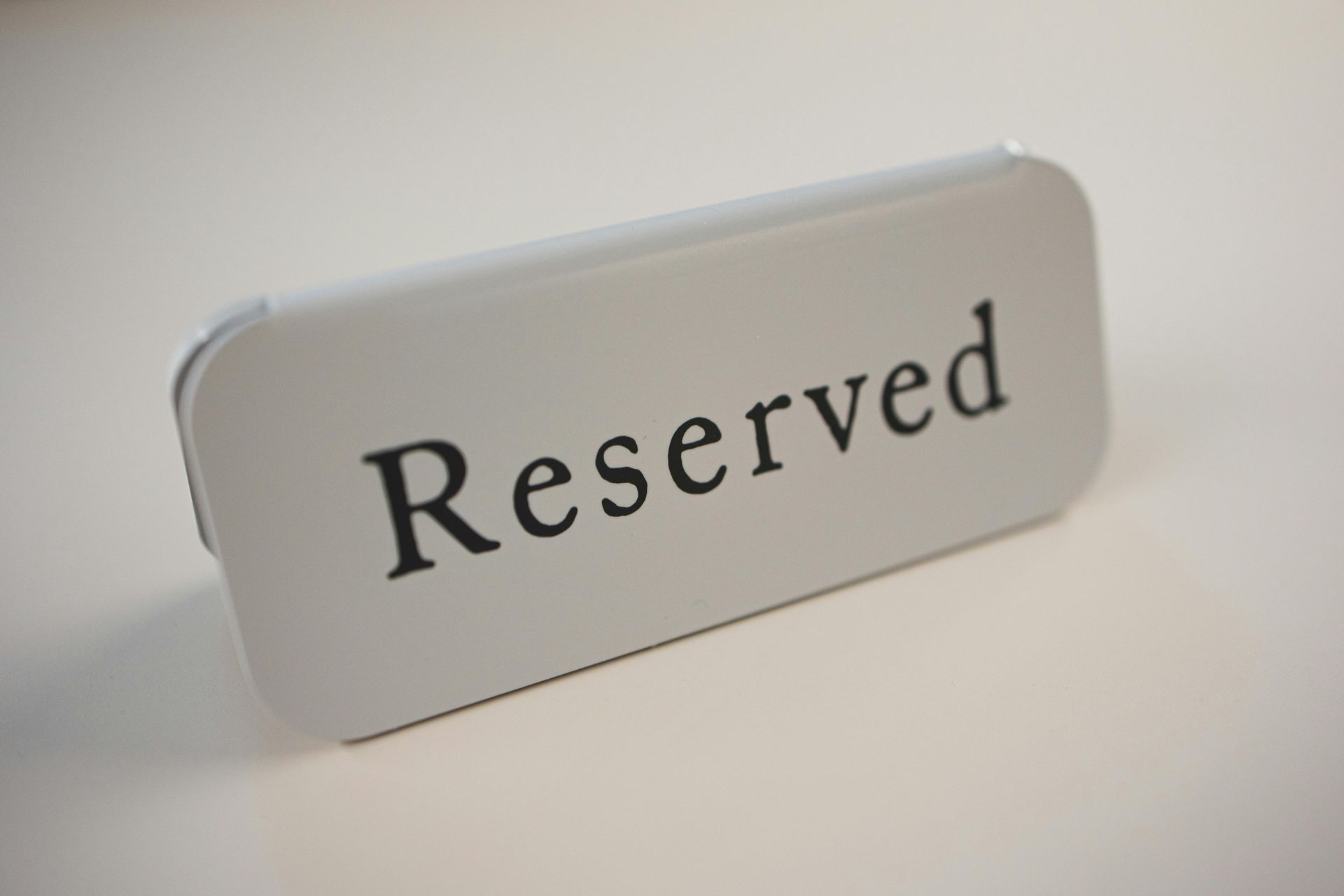 White “Reserved” sign on a white surface.