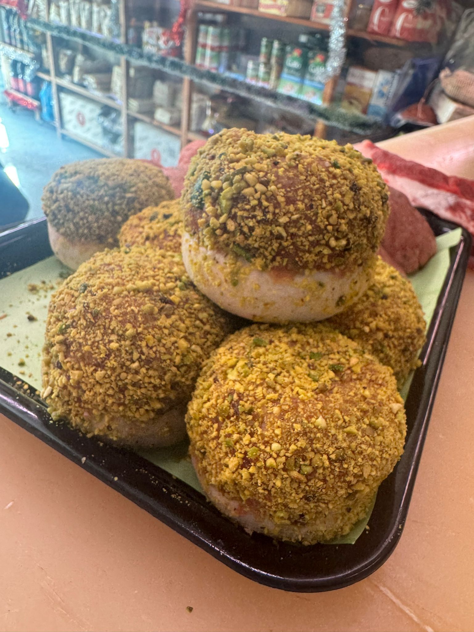 Vassoio di alimenti rotondi ricoperti di briciole verdi e gialle.