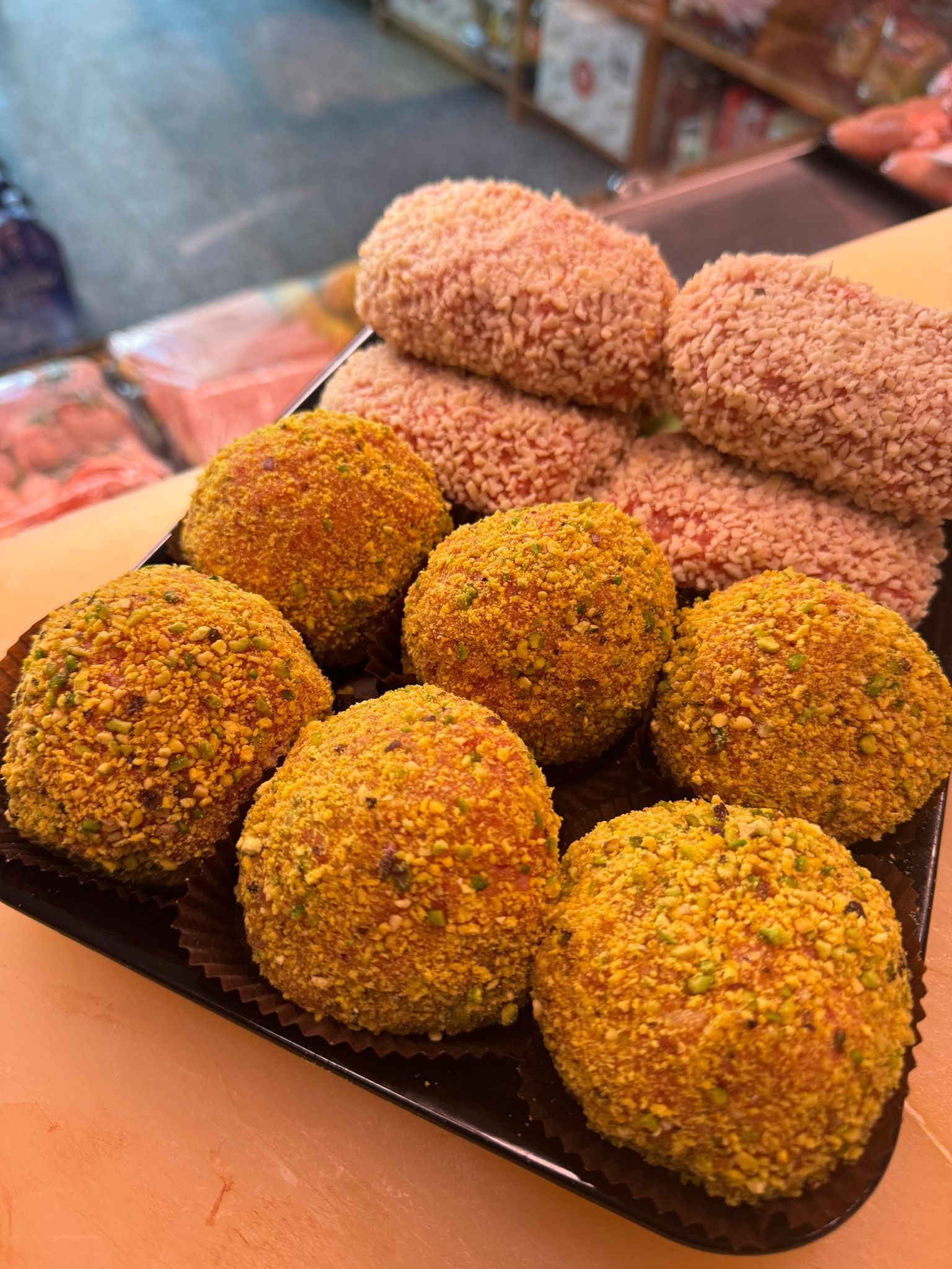 Vassoio di cibo impanato, di forma rotonda e ovale, con una varietà di consistenze e colori, da utilizzare in ambienti chiusi.