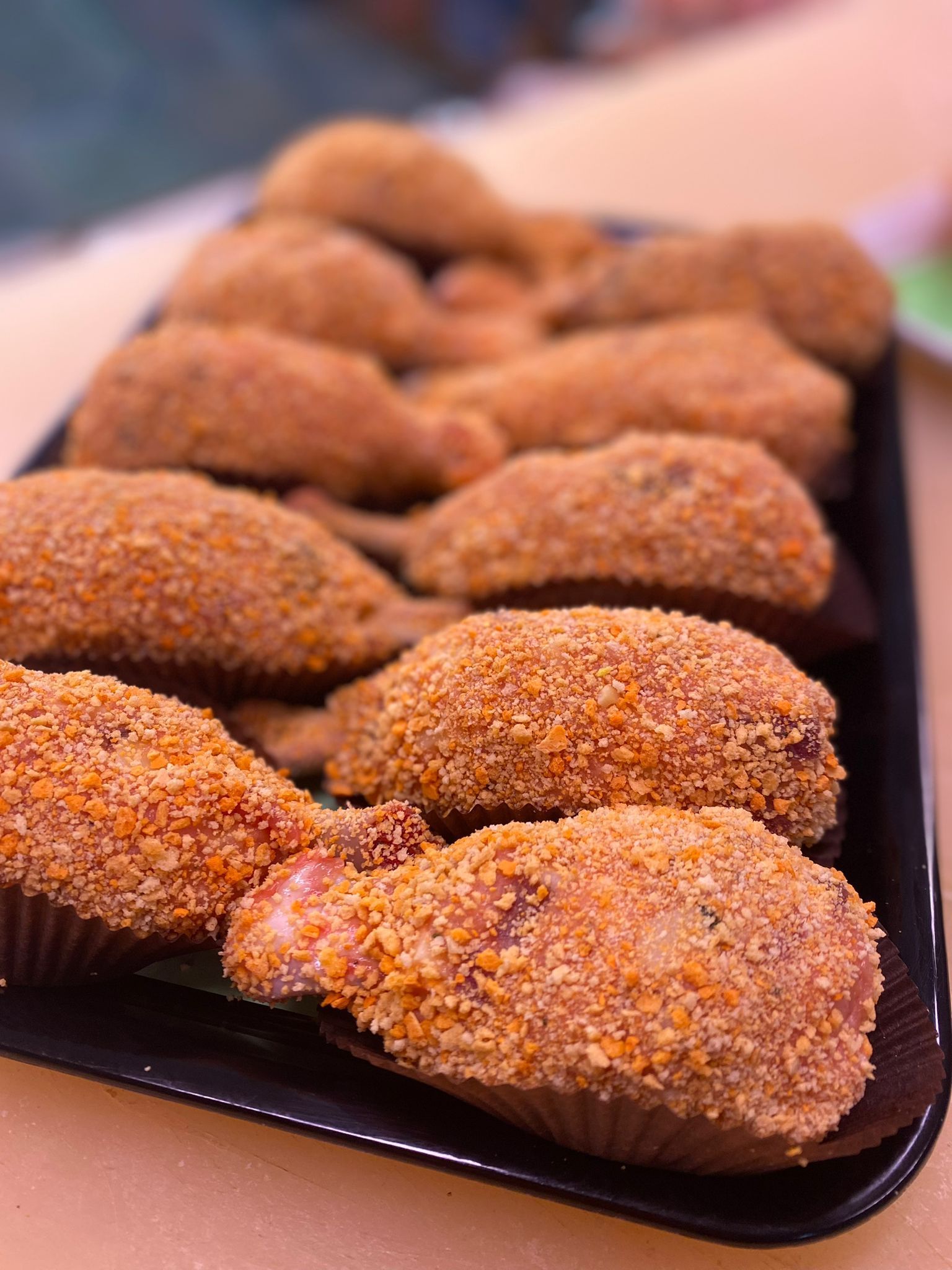 Vassoio di cibo impanato, a forma di cosce di pollo, con una crosta croccante e dorata.