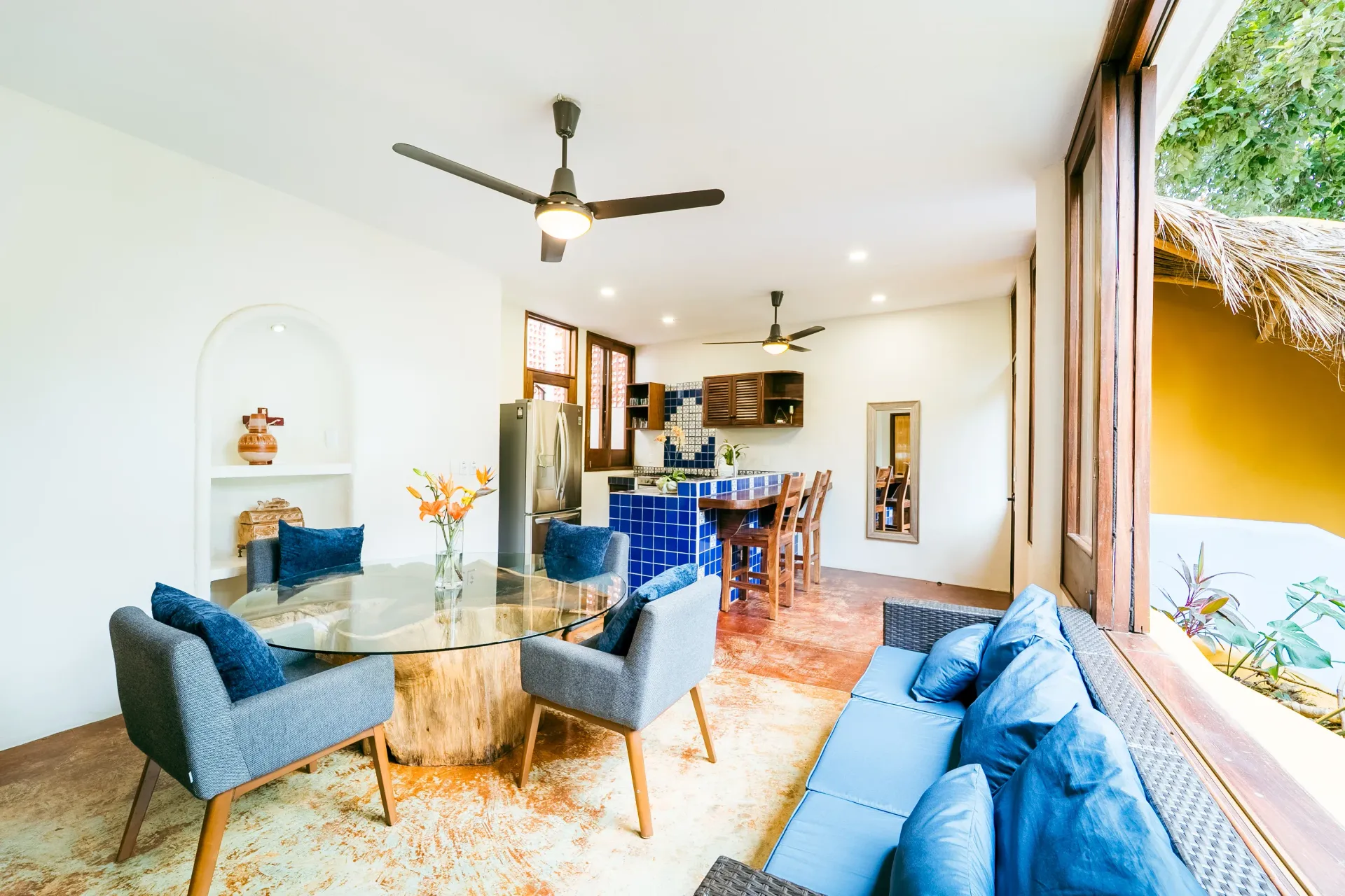 Open concept living area with a round table, sofa, and access to an outdoor area.