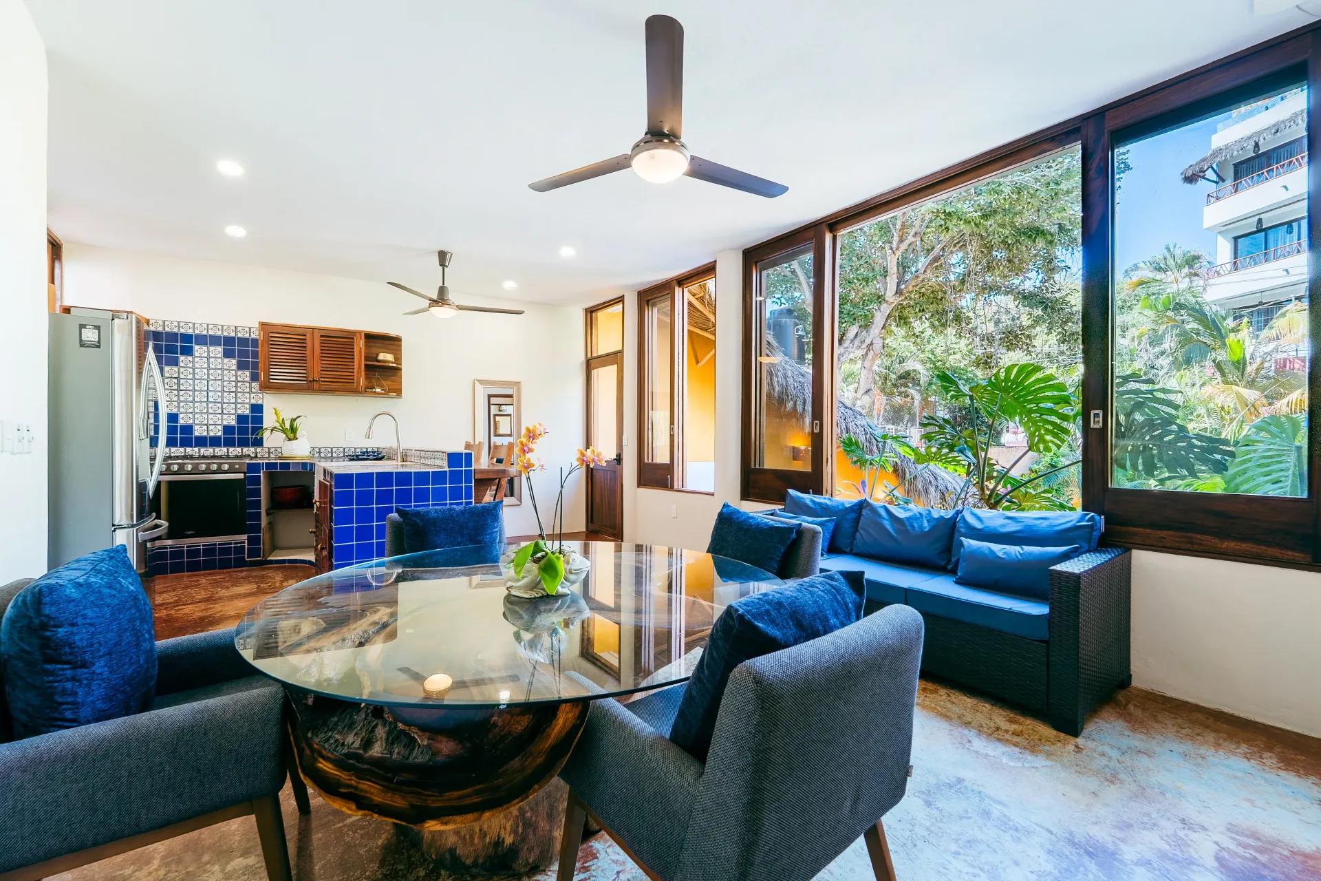 Dining area with table, seating, and kitchen visible through windows.