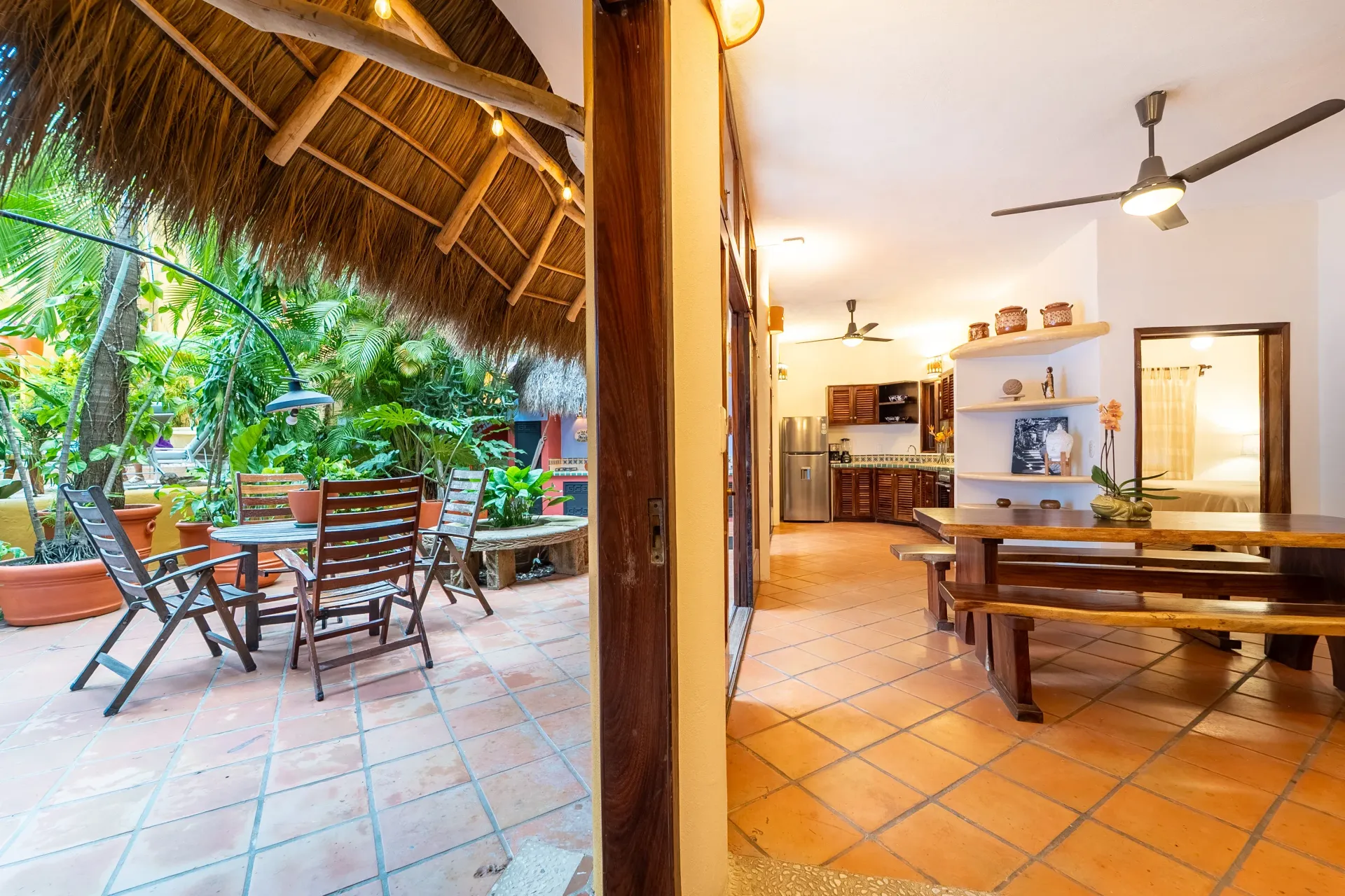 View of an open-air patio with seating and a dining area connected to an interior space with a kitchen.