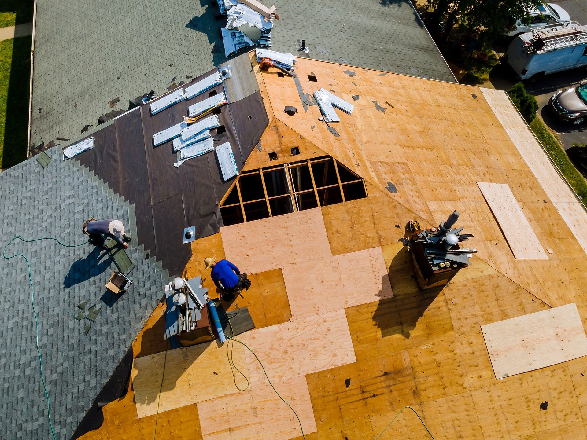 An aerial view of a roof under construction with workers on it.