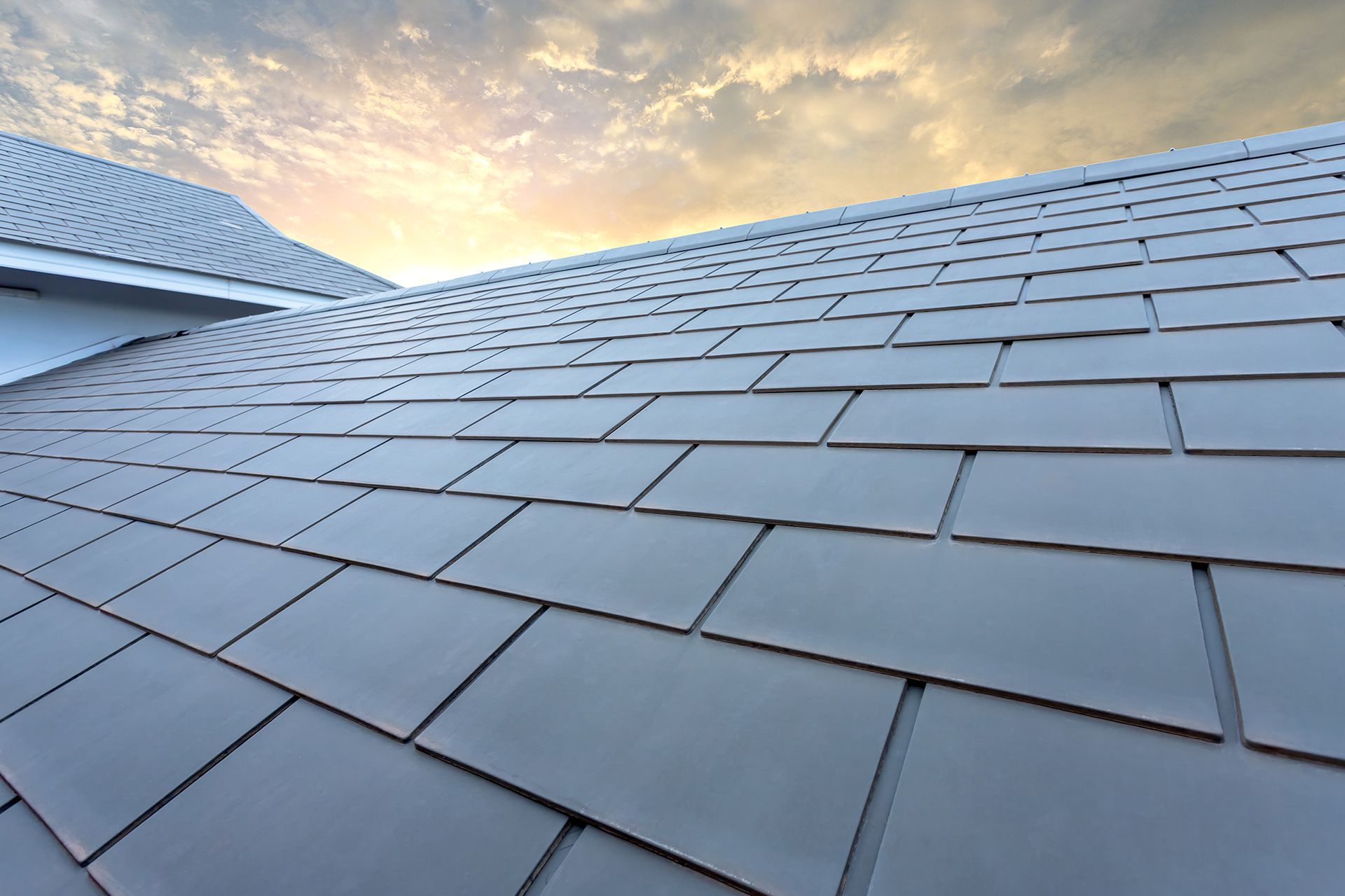 A close up of a roof with a cloudy sky in the background.
