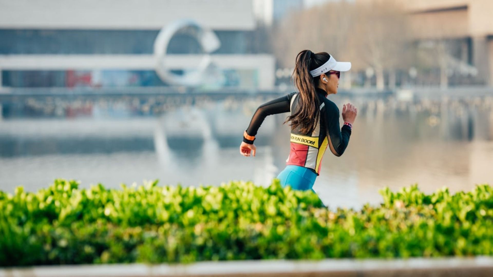 Una mujer que lleva una visera está corriendo en un parque.