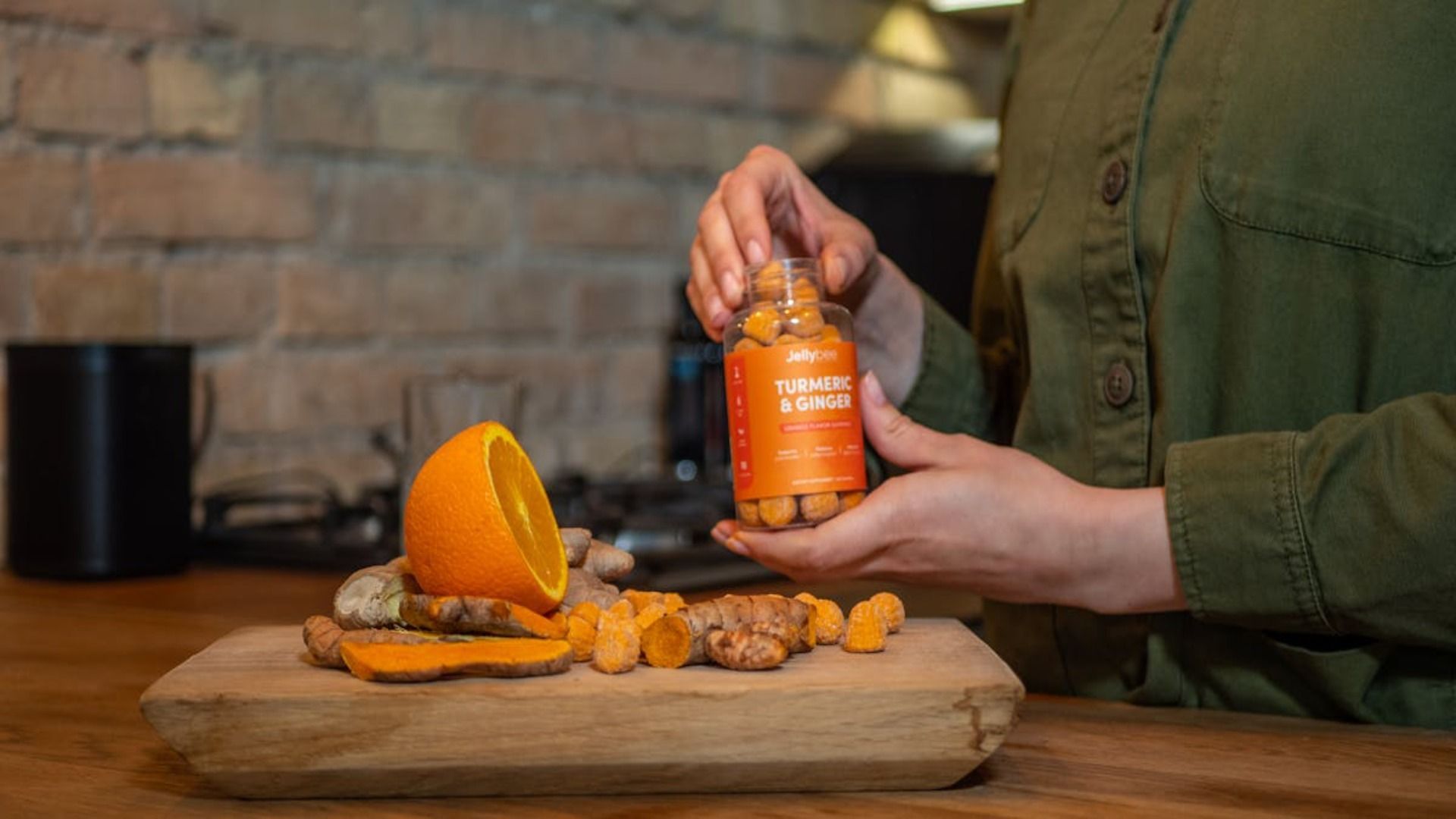Una mujer sostiene un frasco de cúrcuma y jengibre.