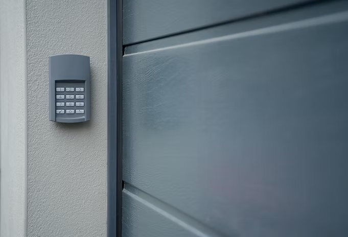 A close up of a remote control on the side of a garage door.