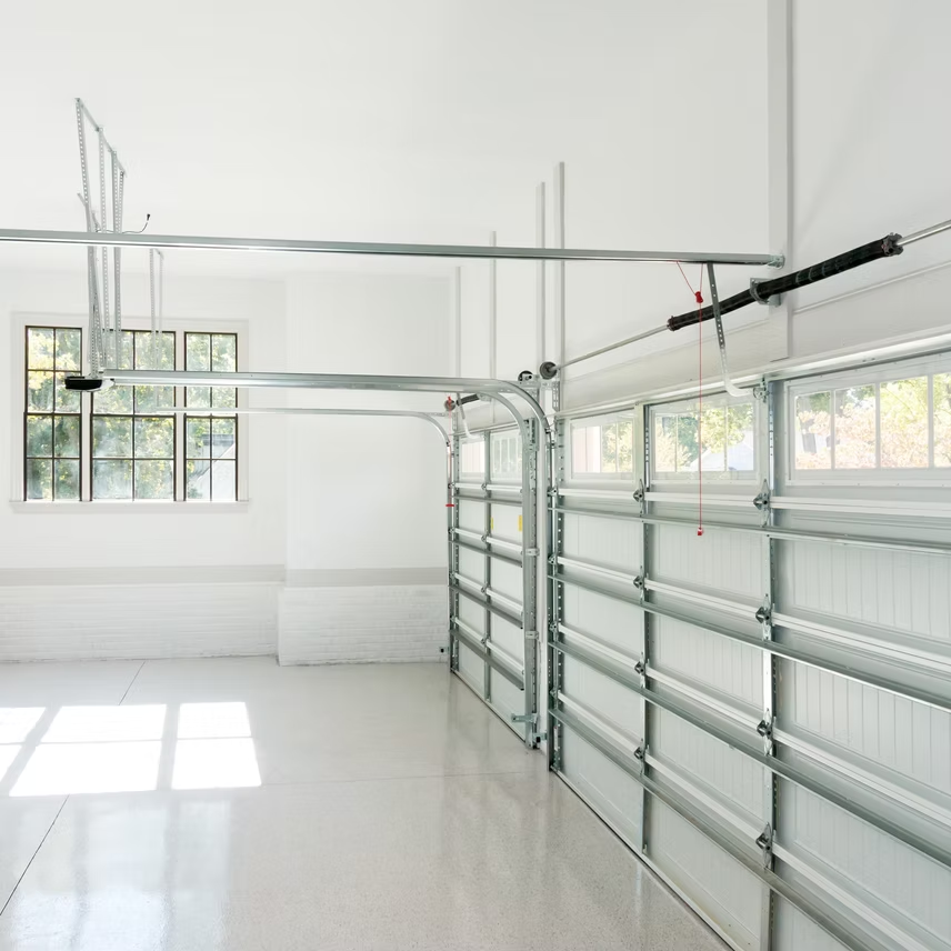 An empty garage with a basketball hoop hanging from the ceiling
