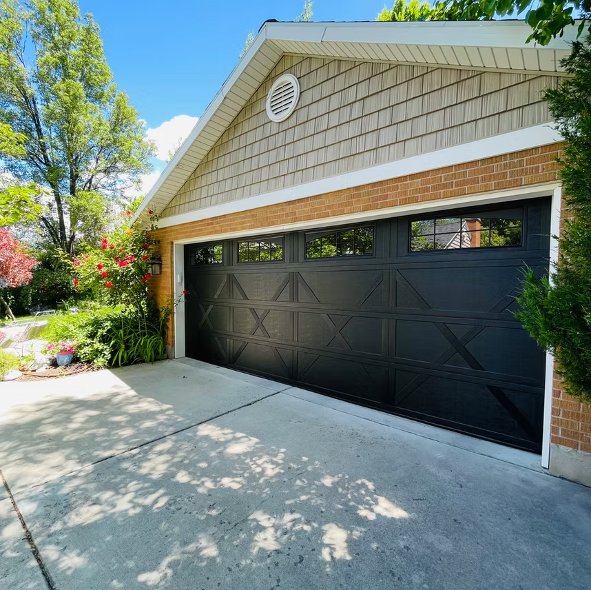 A brick house with a black garage door