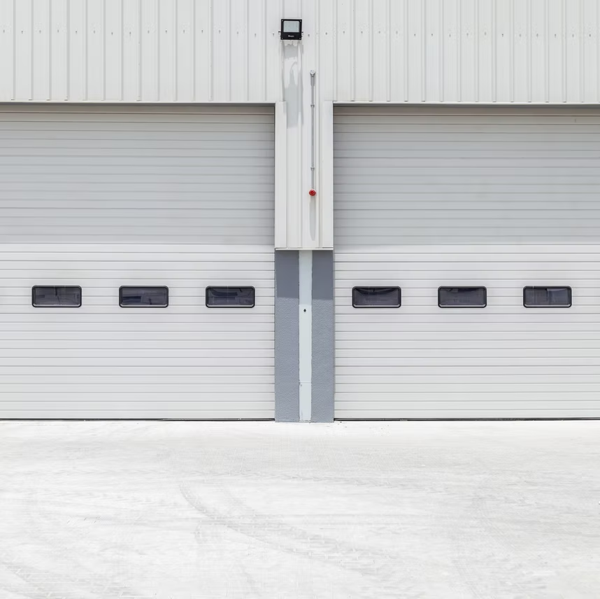 There are two garage doors on the side of a building.