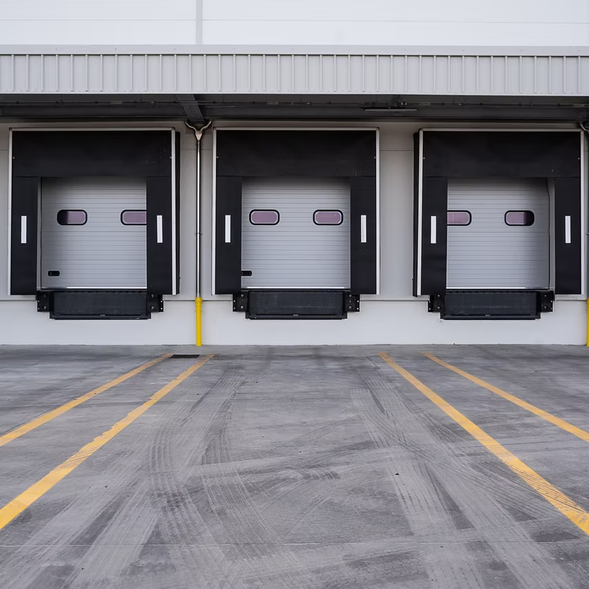 A row of loading docks are lined up in a parking lot