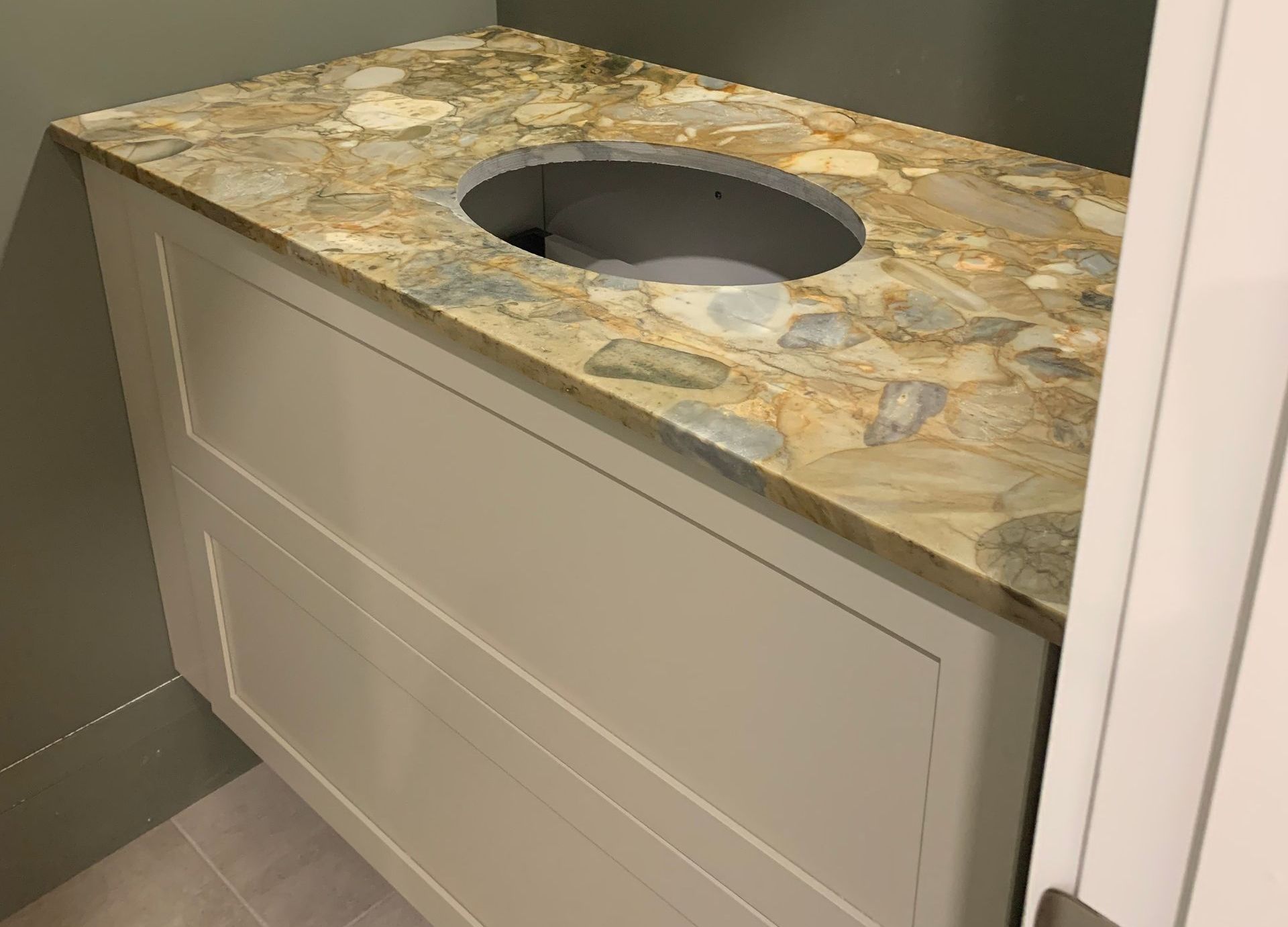 A bathroom with a sink and a marble counter top.