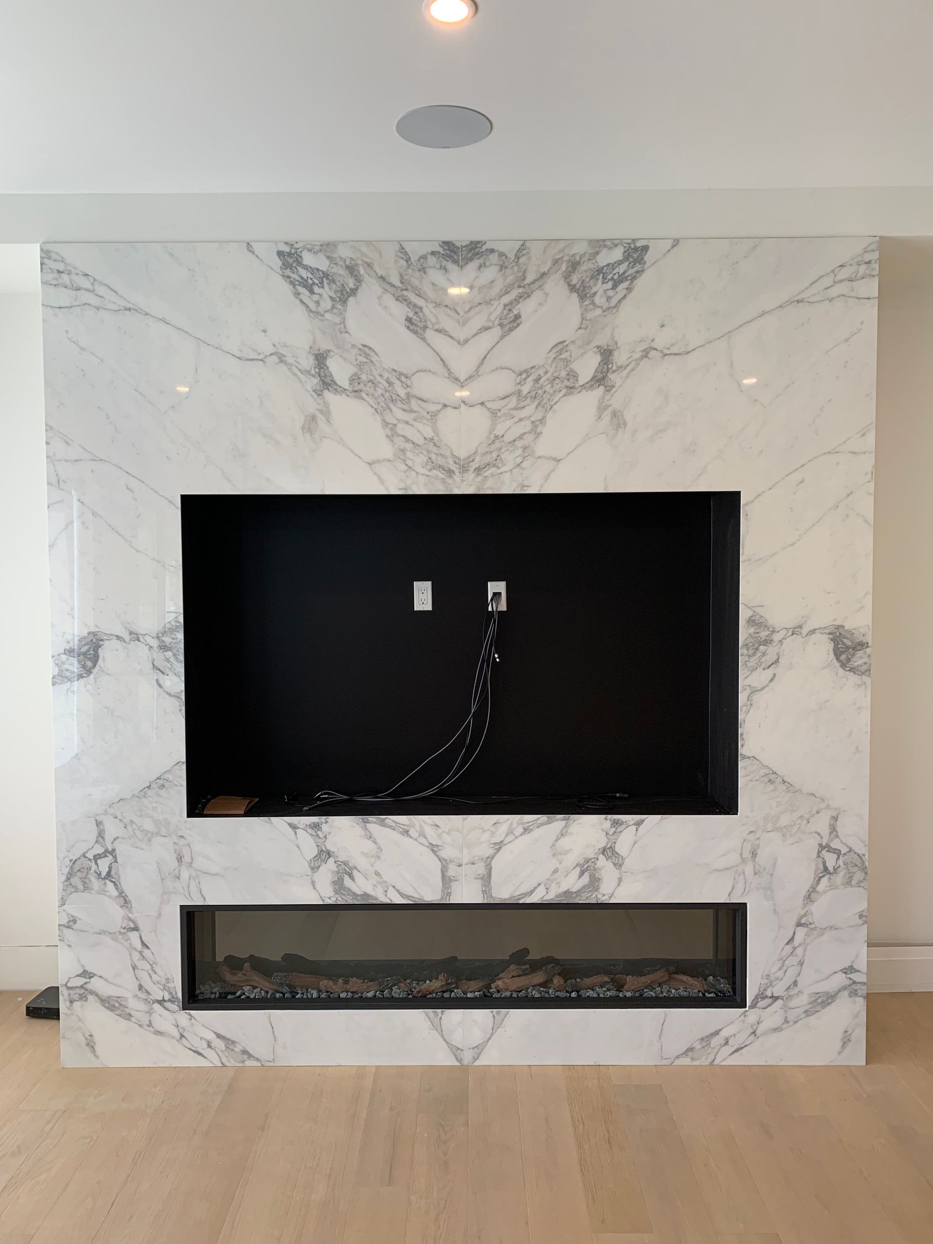 A living room with a fireplace and a television mounted on the wall.