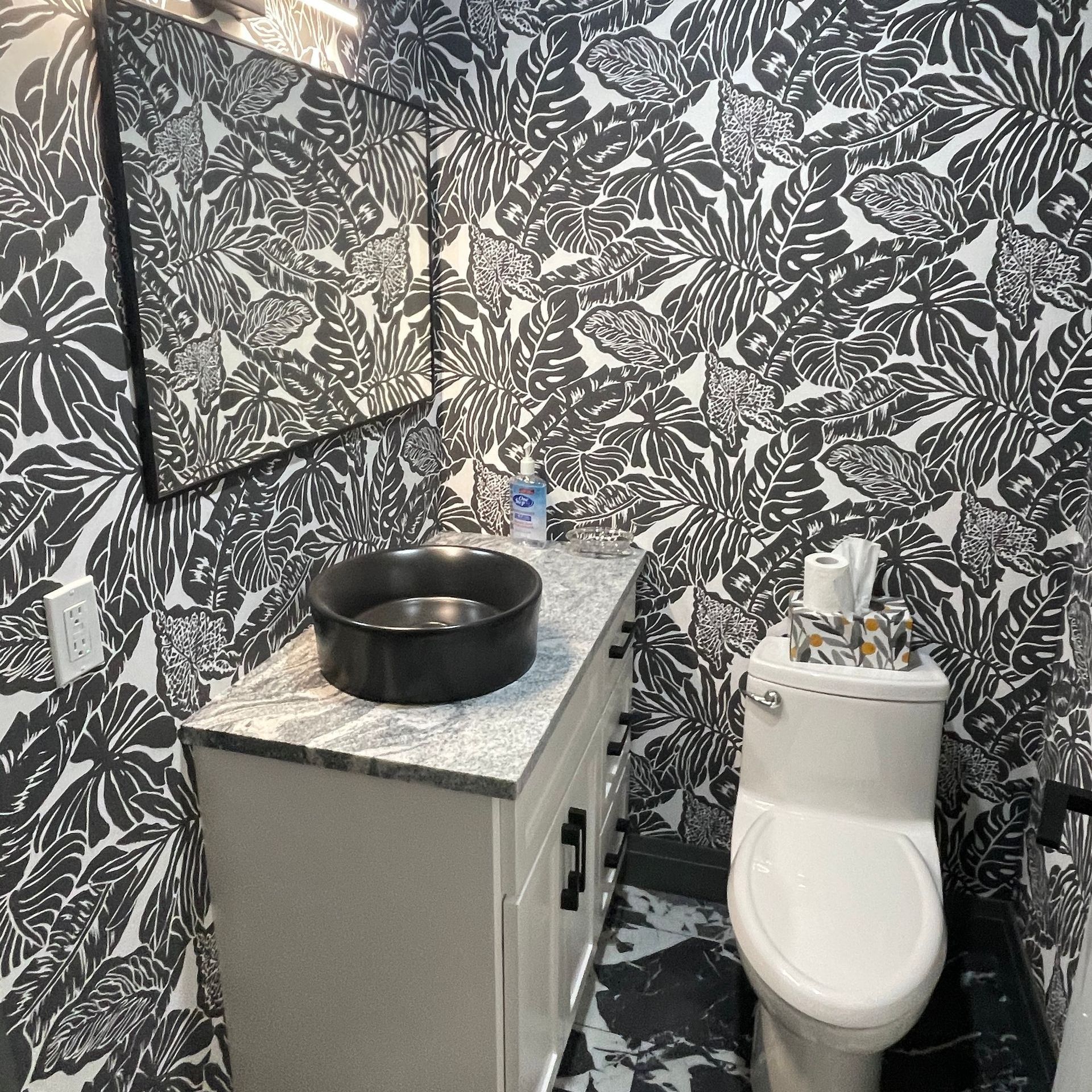 A bathroom with a toilet , sink and mirror.