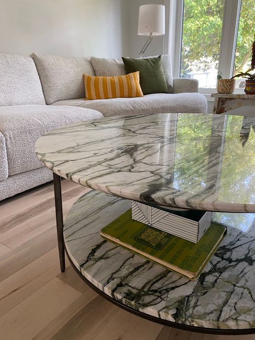 A living room with a marble coffee table and a couch.