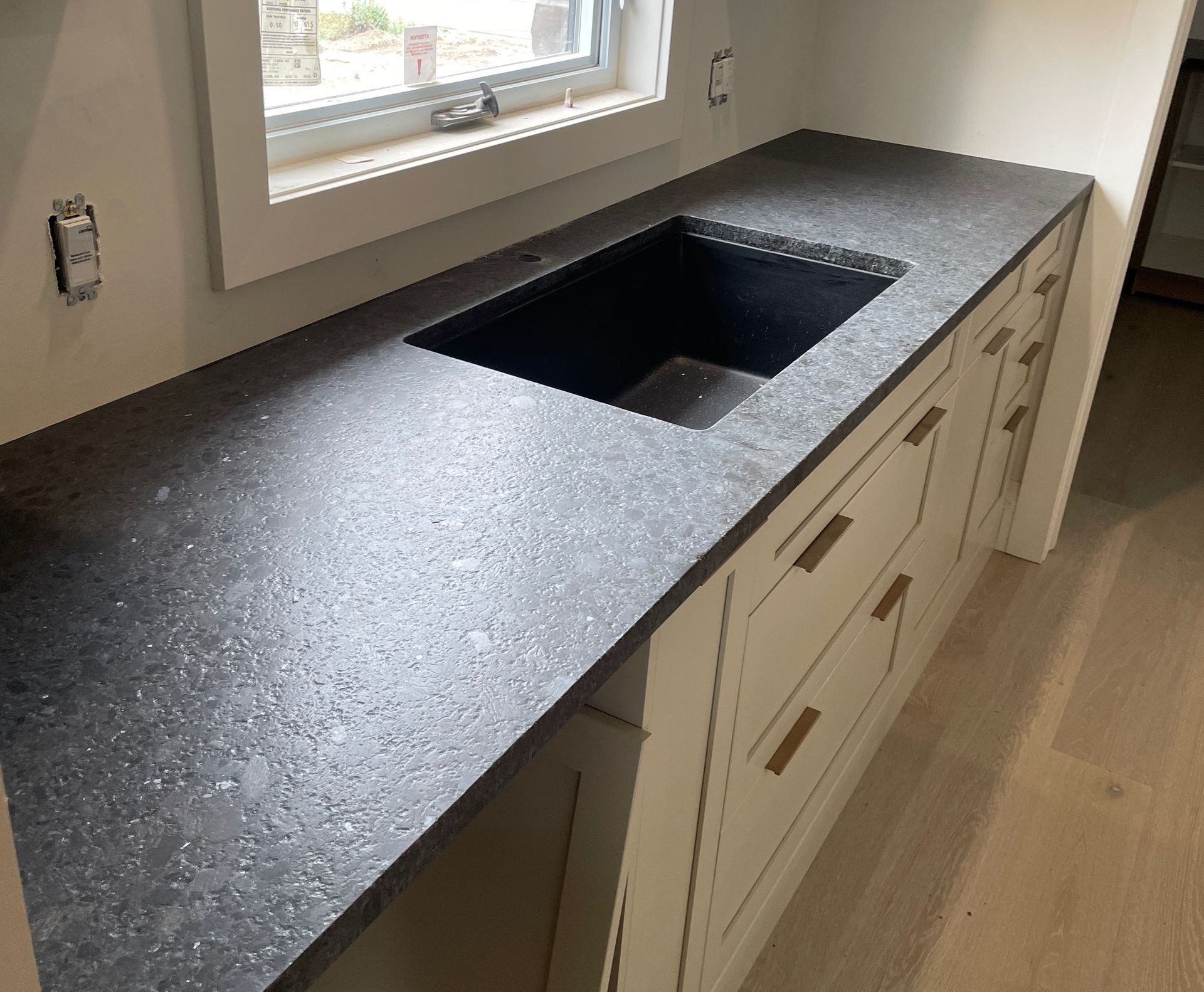 A kitchen counter with a sink and a window.