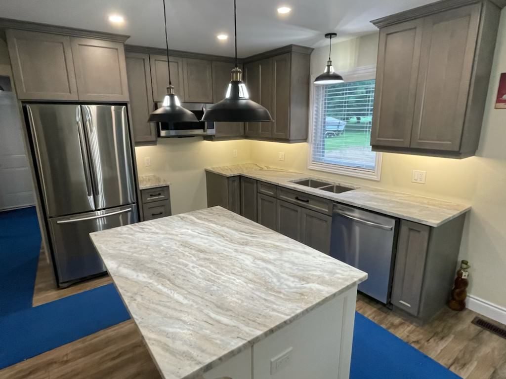 Gray kitchen with island and stainless steel appliances.